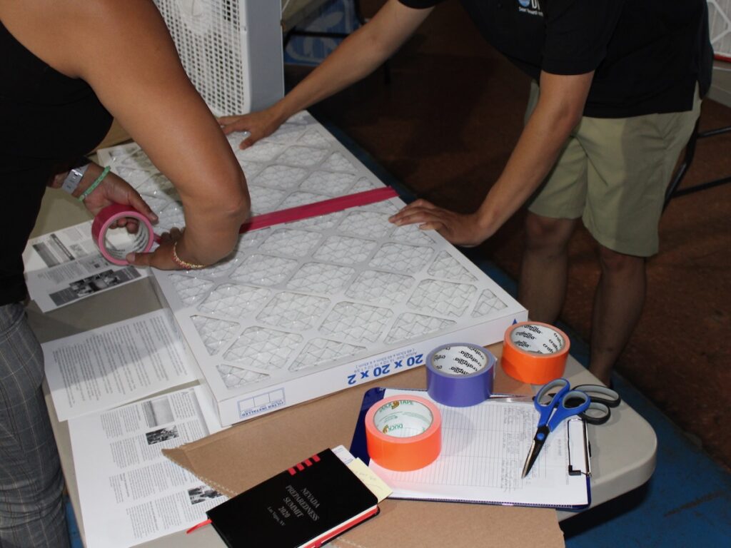 workshop participants tape two filters together using duct tape