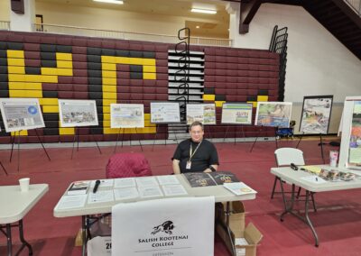 Man sitting at table in front of posters.