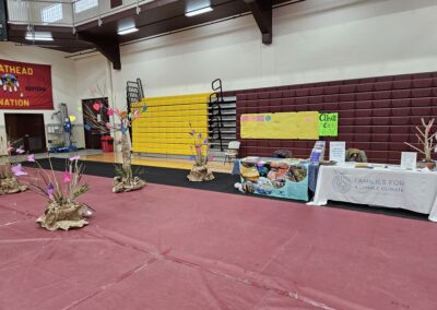 Brown paper trees with colorful paper leaves next to two tables with informational pamphlets