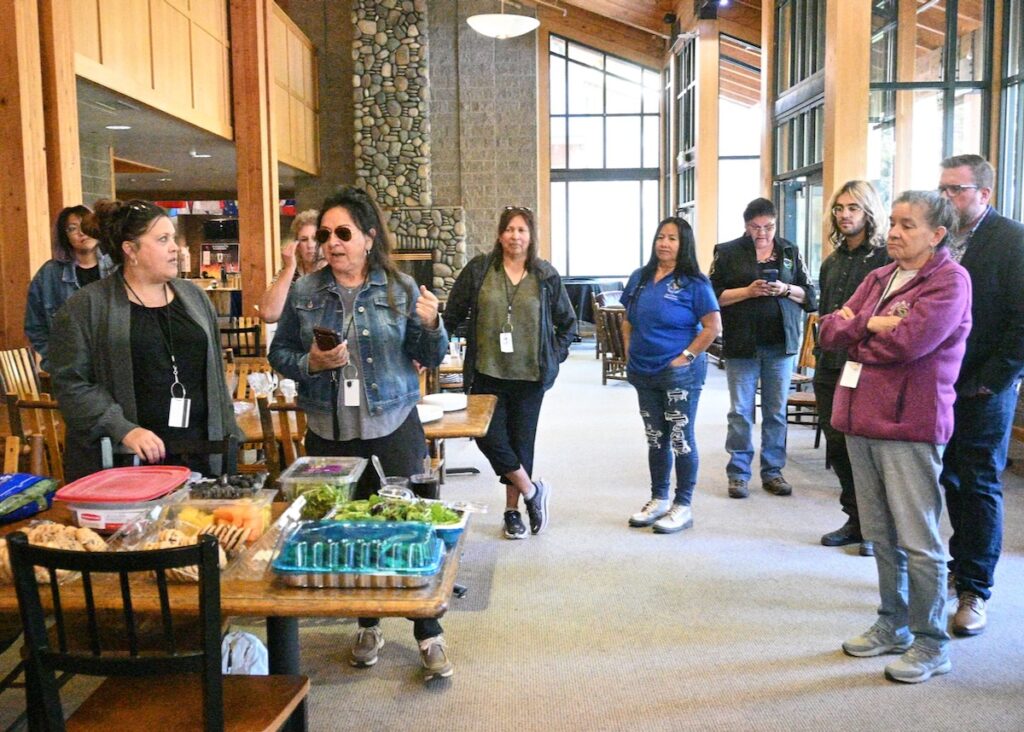 Potluck participants tell each other about the foods they have prepared. Time to eat!