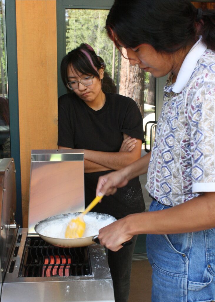 Tessa Smartt and Lance Owyhee of the Desert Farming Initiative heat a flour mixture to begin their chokecherry pudding.