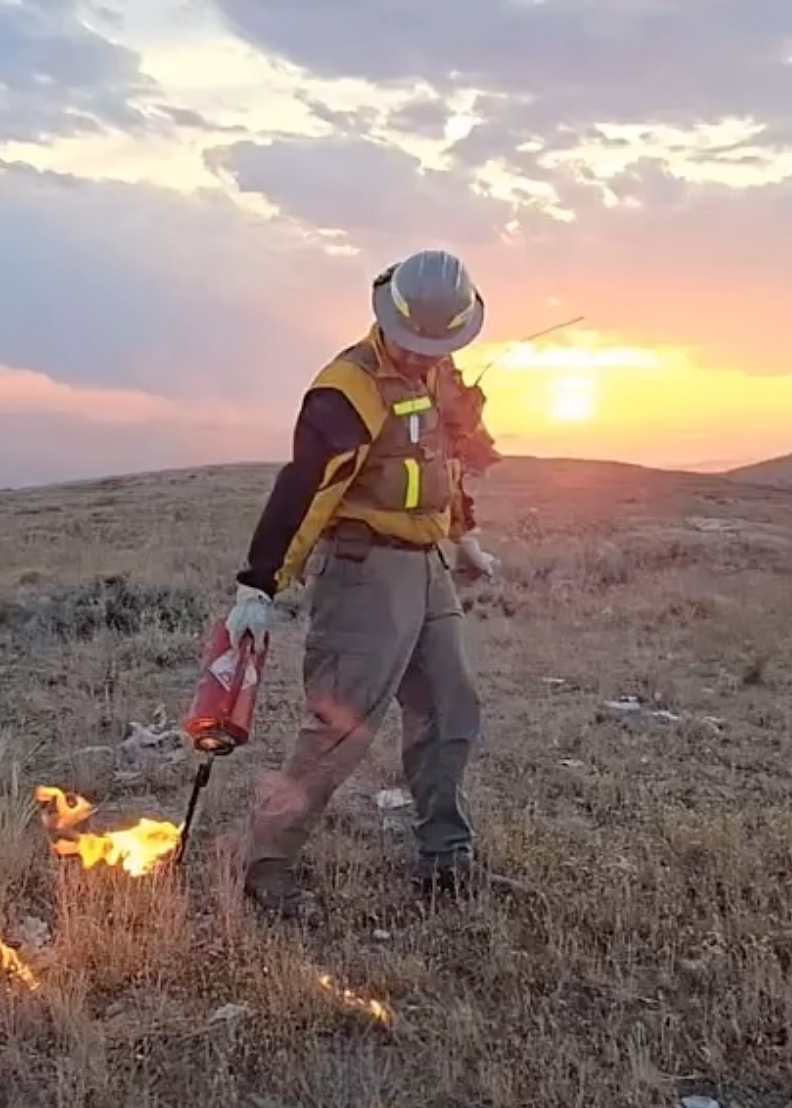 Firefighter Noah Valdez lights a fire using a drip torch